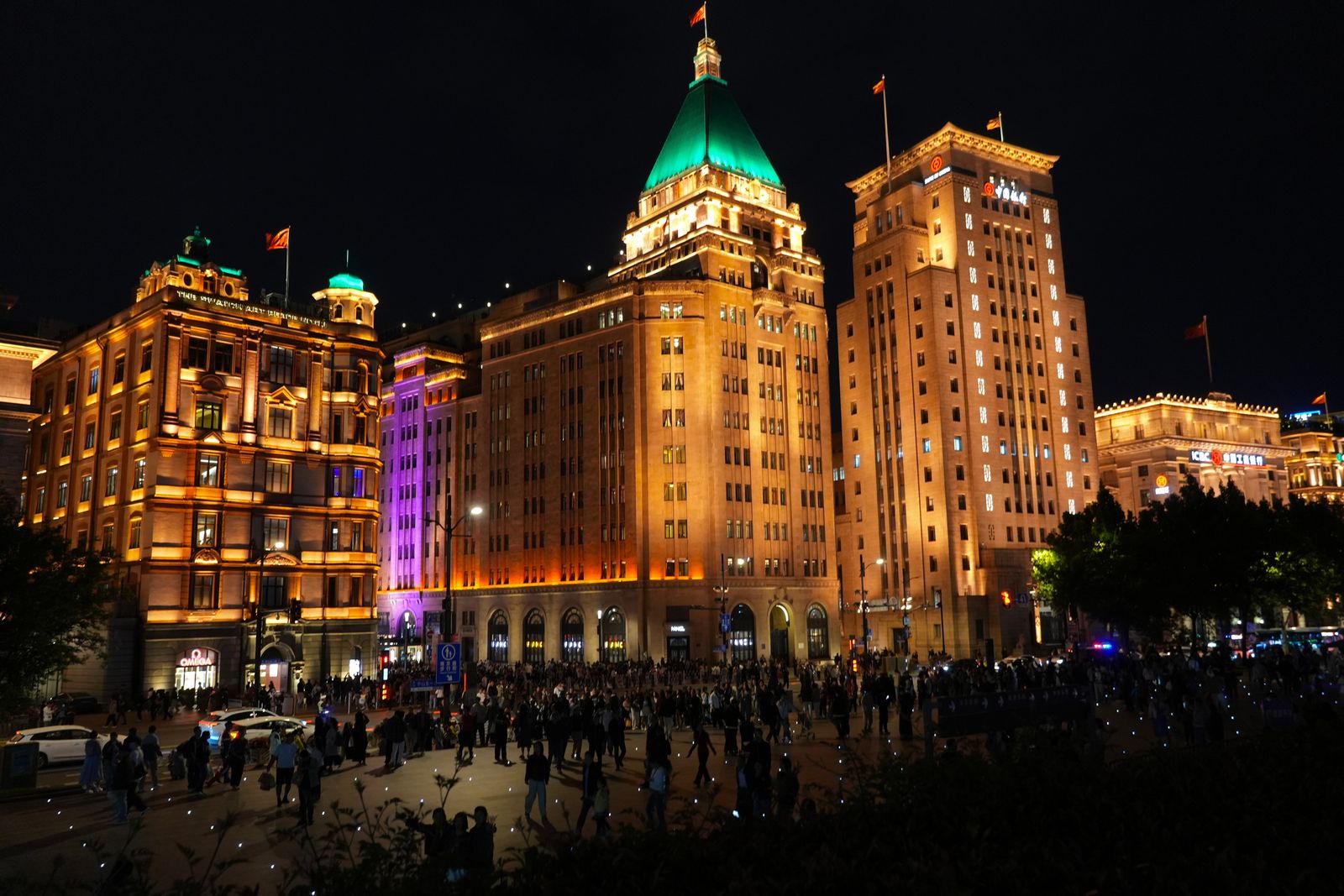 Gold-lit buildings above a crowded pedestrian area at night, Shanghai