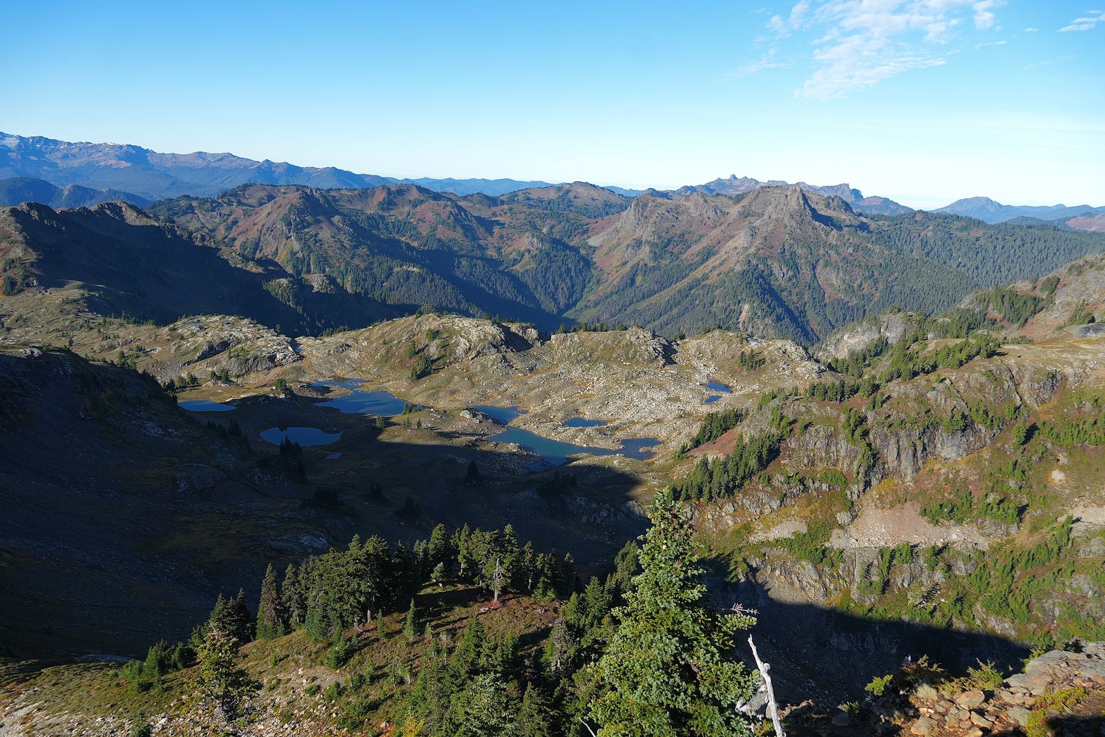 Rocky mountain ridges above small tarns and tree-covered slopes, Yellow Aster Butte