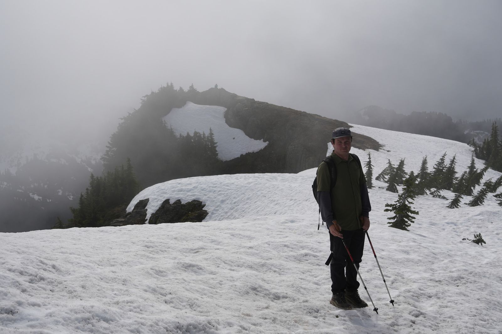 A hiker on a snowy rocky ridge in fog, Ball Mountain