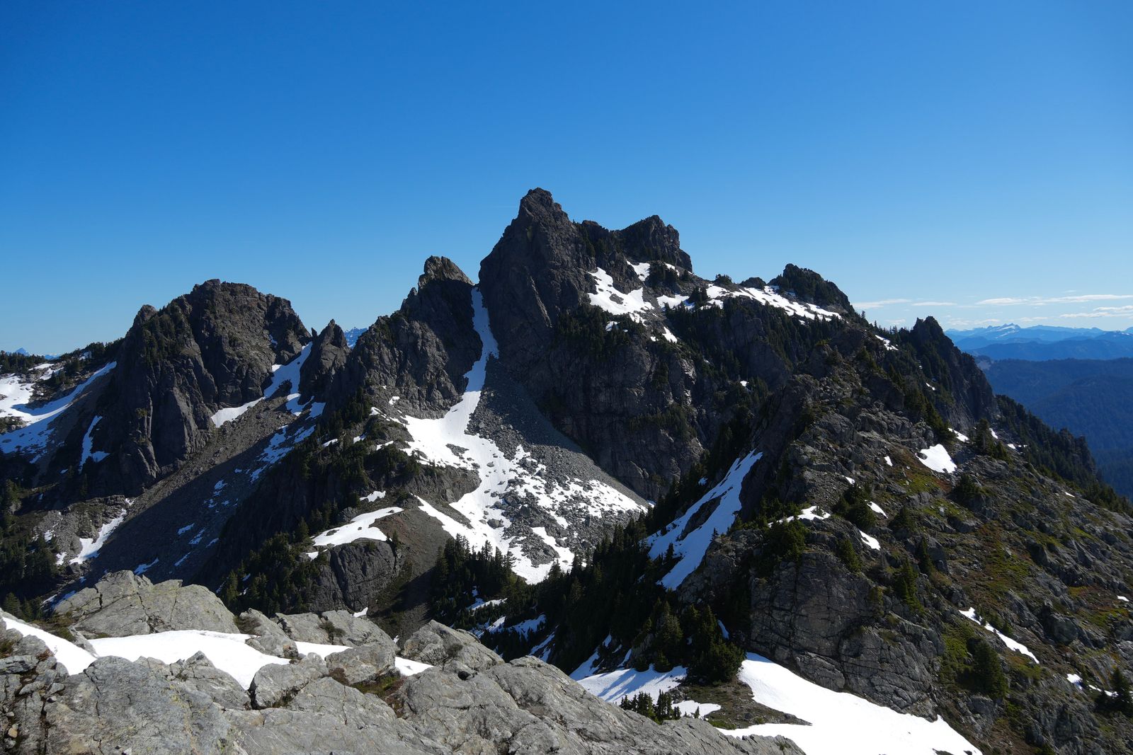 Rocky peaks above snow-filled gullies and scattered trees, Gunn Peak