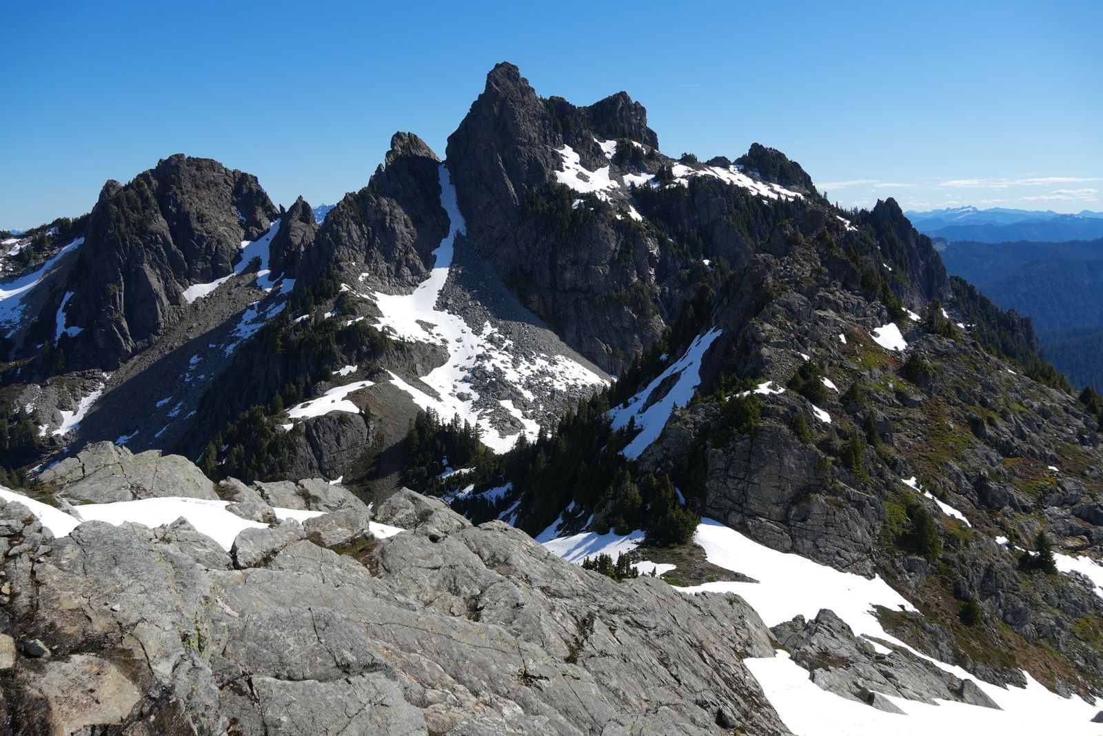 Rocky peaks above broad rock slabs and scattered trees, Gunn Peak