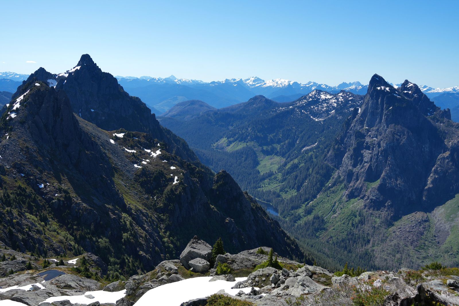 Rocky peaks above a forested valley, boulders and snow, Gunn Peak