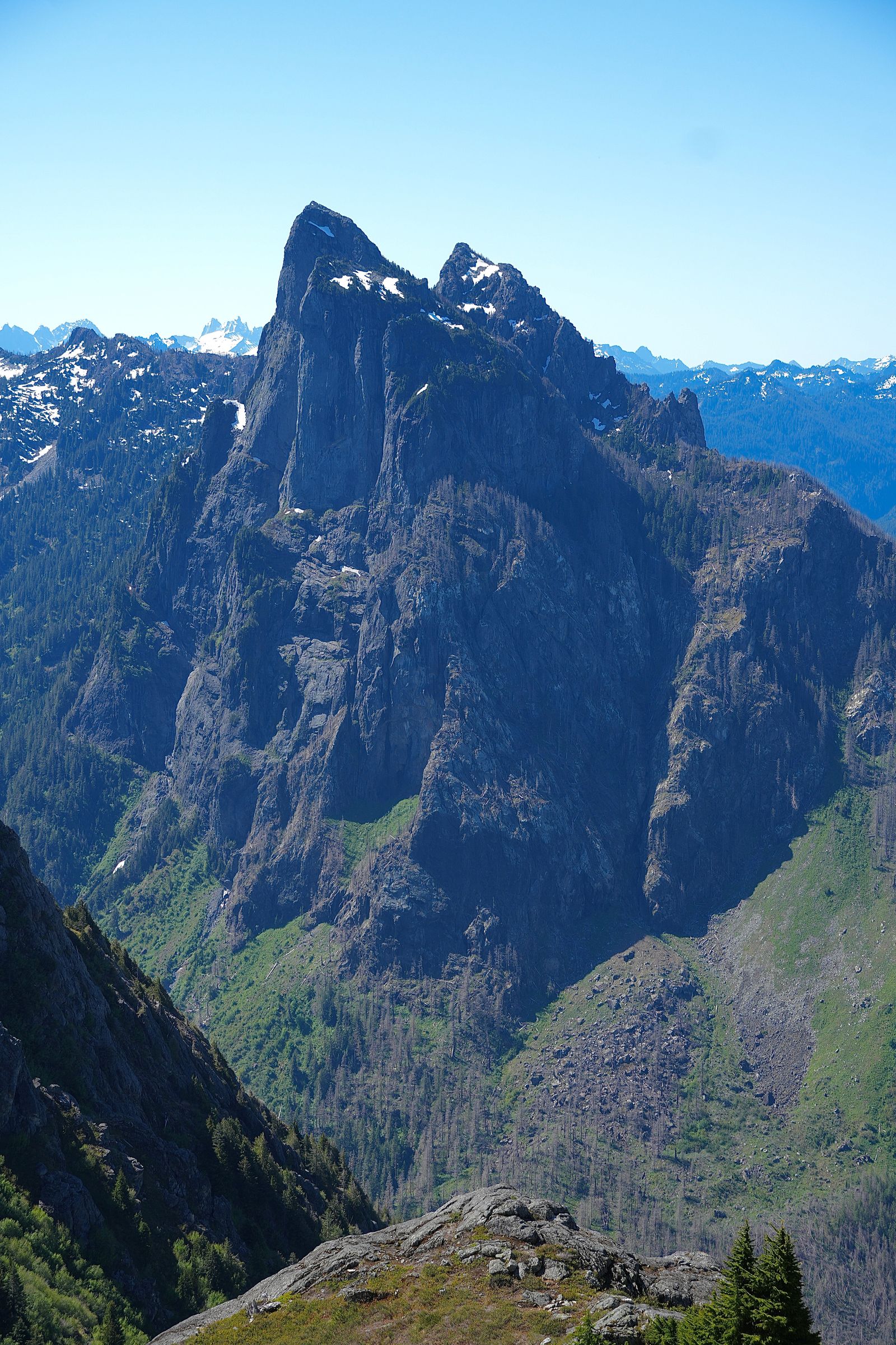 A rocky peak above green slopes and a rocky ledge, Gunn Peak