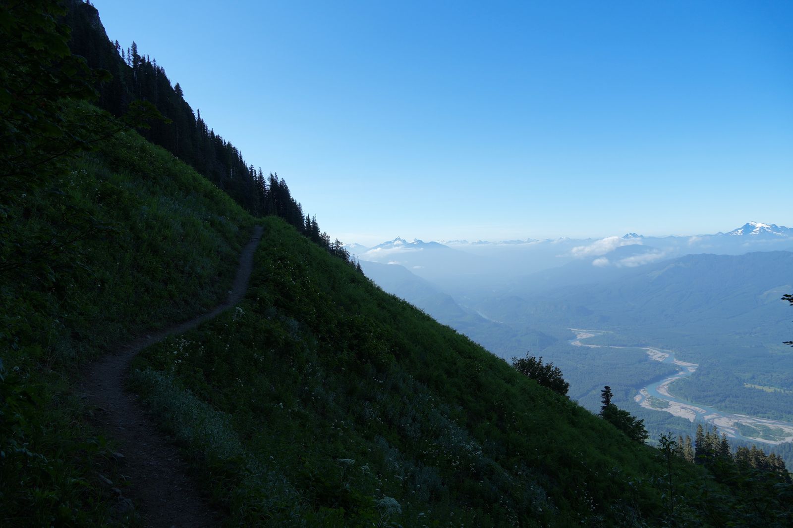 Mountain trail across a green slope above a winding river, Sauk Mountain