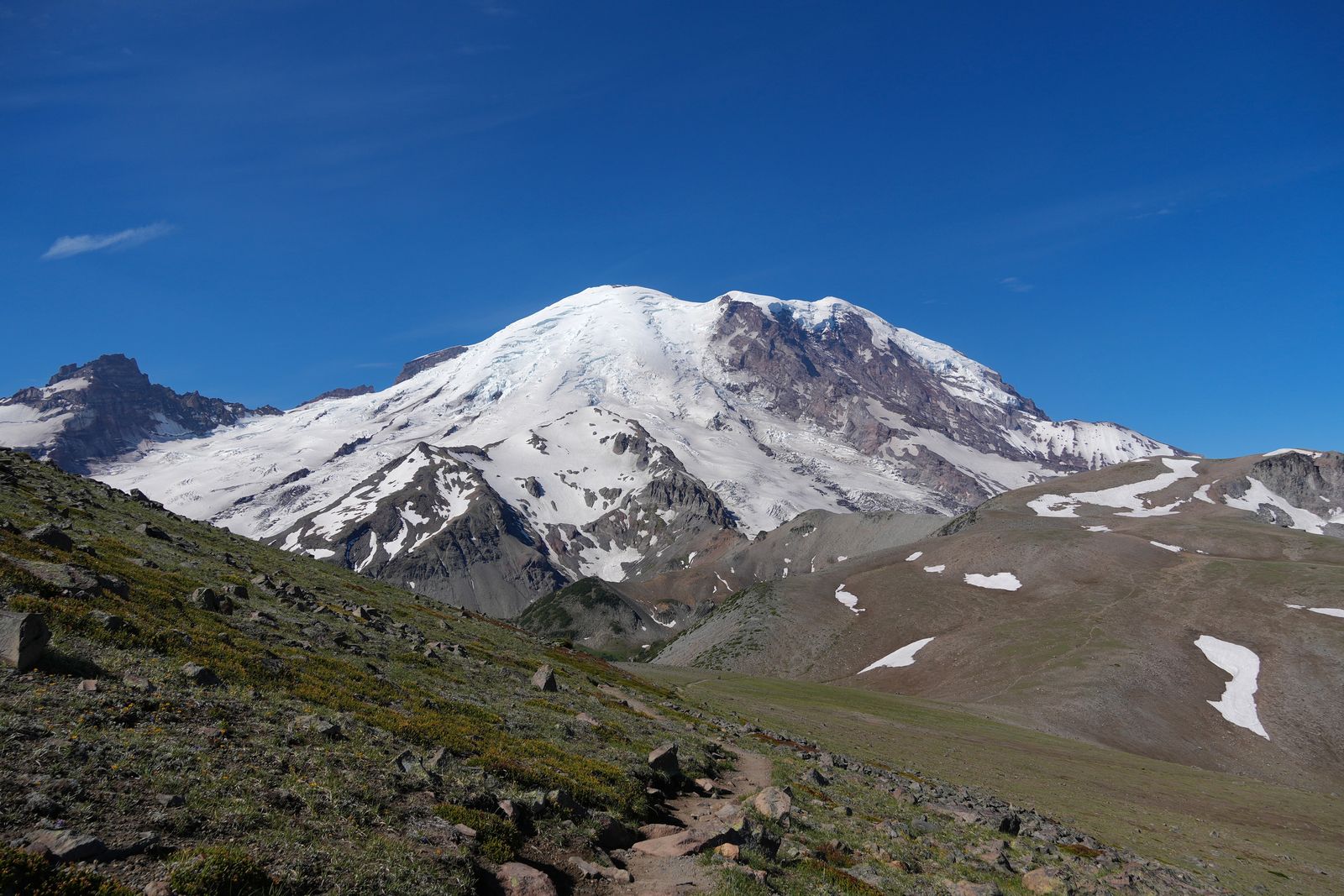 Mount Rainier above a narrow trail and snowy slopes, Sunrise