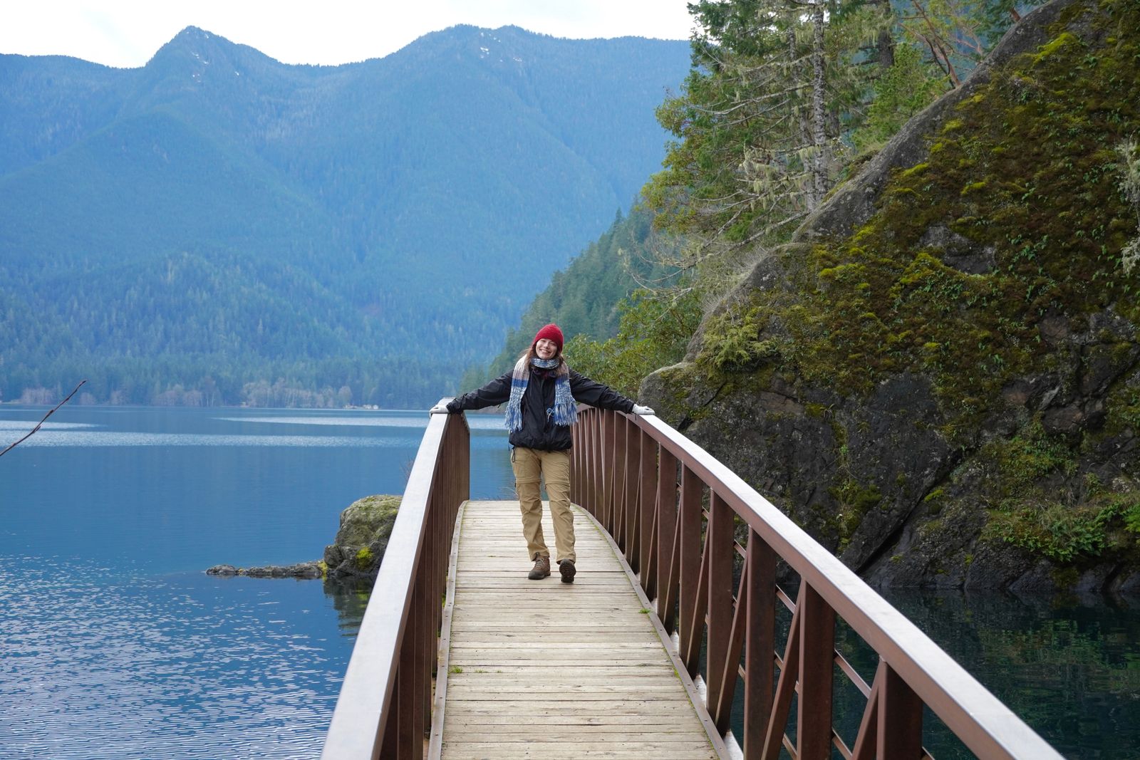 A person on a footbridge beside a mountain lake, Olympic National Park
