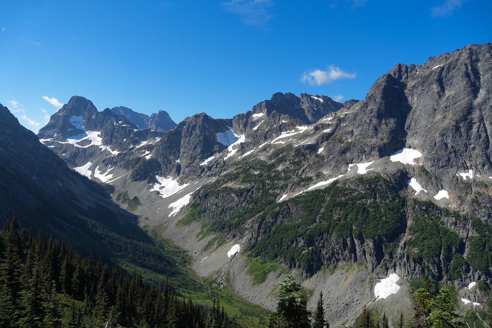 Snow-streaked North Cascades peaks above a forested valley, Washington Pass