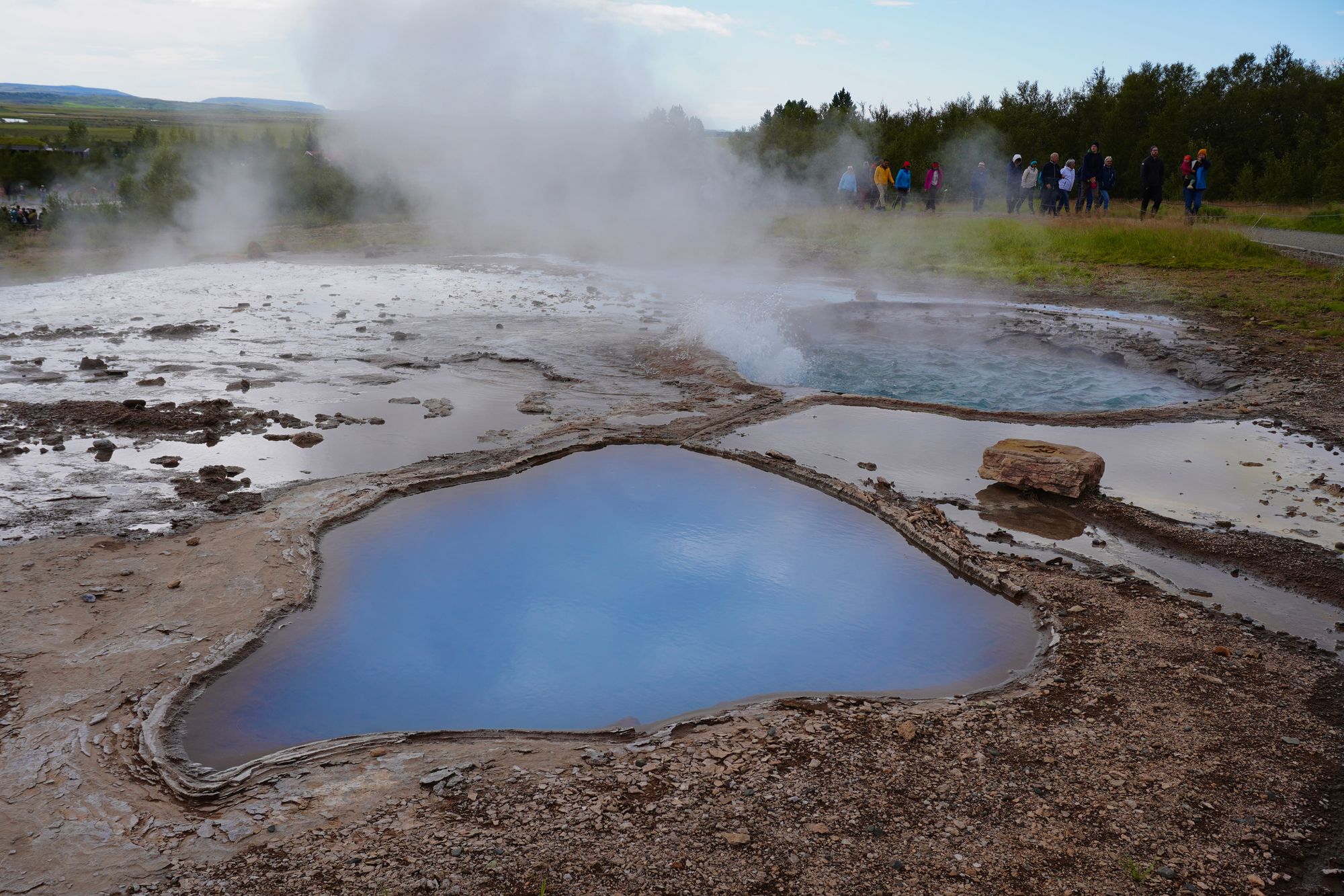 Blue pool and steaming pool surrounded by mineral crust, Bláskógabyggð