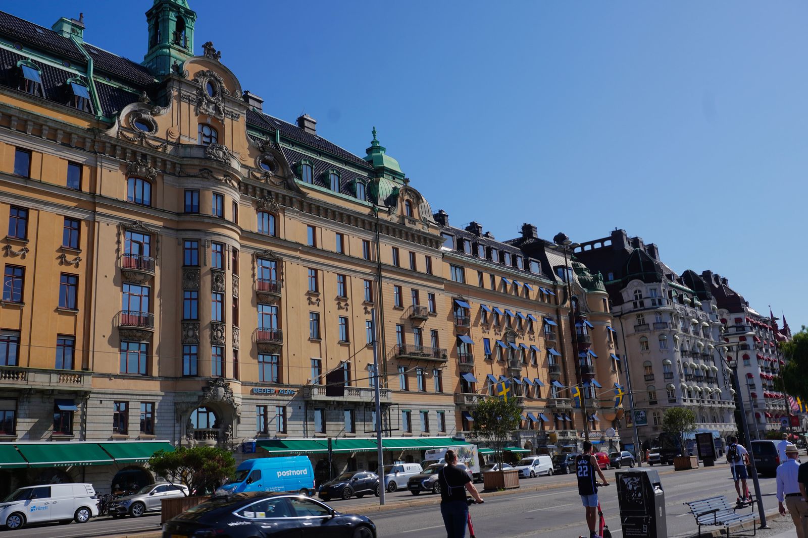 Ornate buildings lining a Stockholm street with cars and pedestrians
