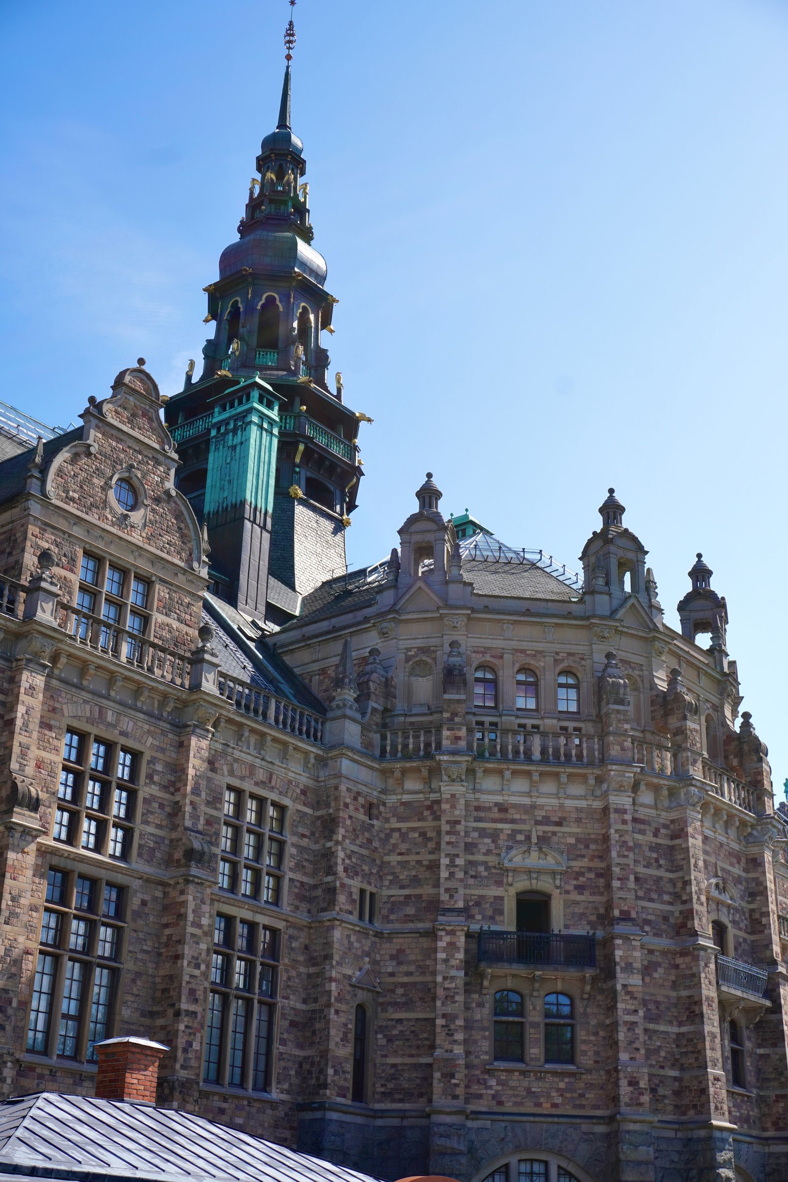 Ornate brick building with a tall green metal spire, Stockholm