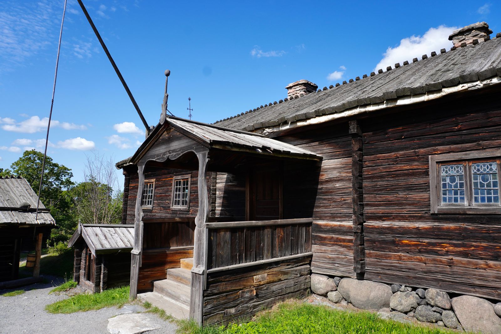 Wooden building with a covered porch beside a gravel path, Stockholm