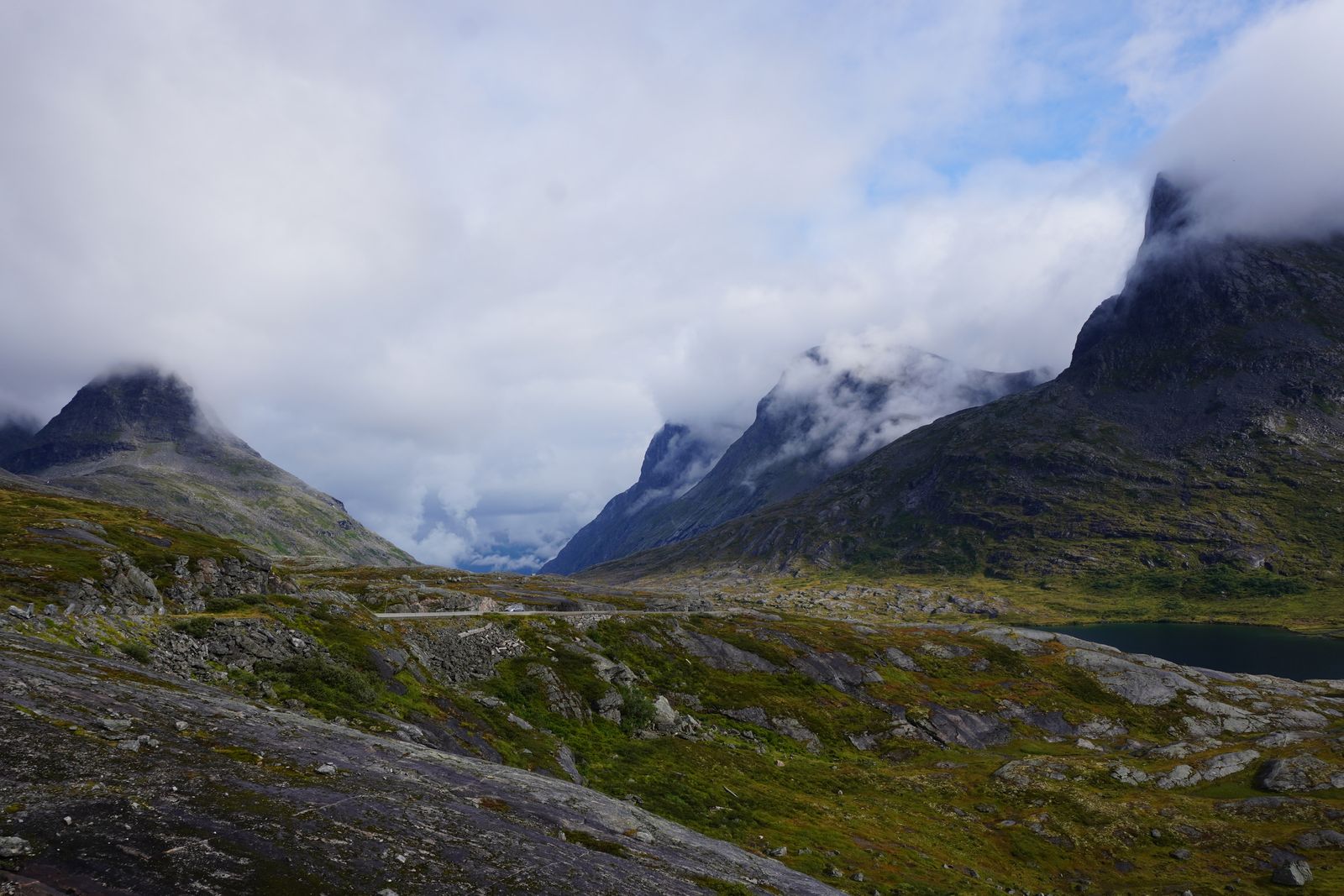 Rocky peaks above a road and tarn in fog, Trollstigen