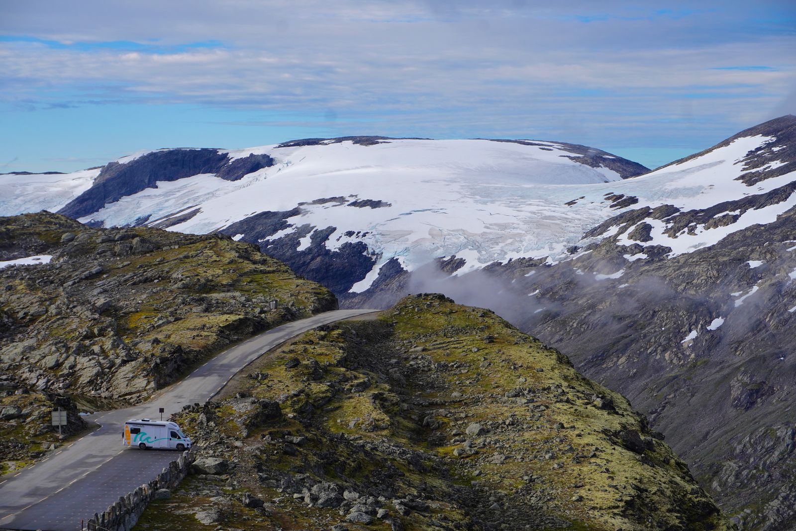 Glacier above a winding road with a camper van, Geiranger