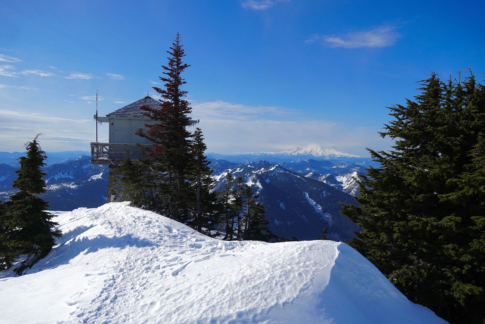 Lookout tower above a snowy ridge with mountains beyond, Western Washington