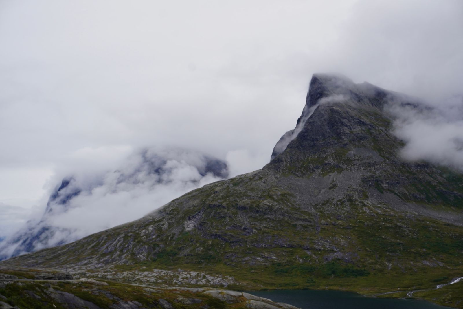 Rocky mountain peak above a tarn in low cloud, Åndalsnes