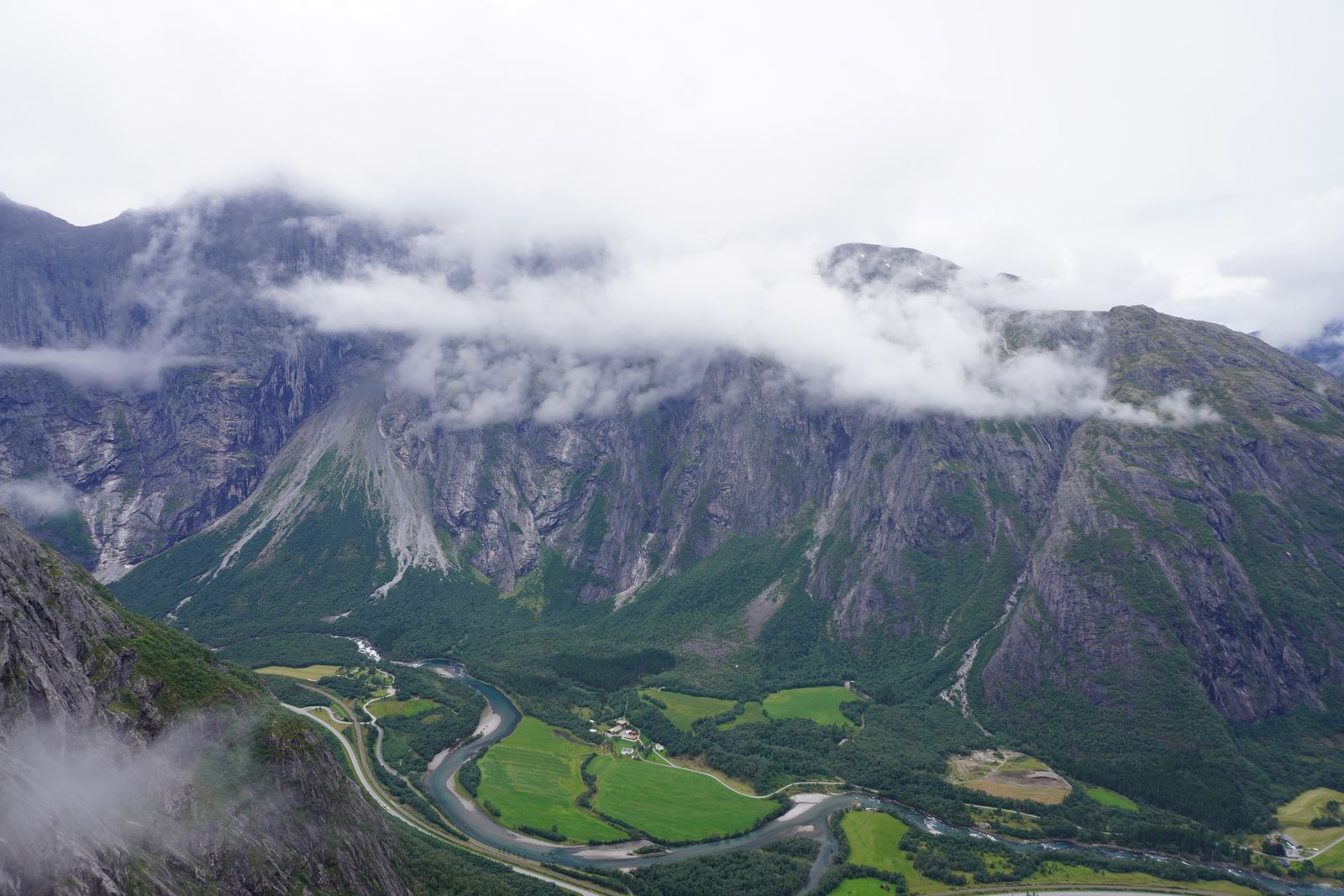 Rocky mountains above a winding river and green fields, Åndalsnes