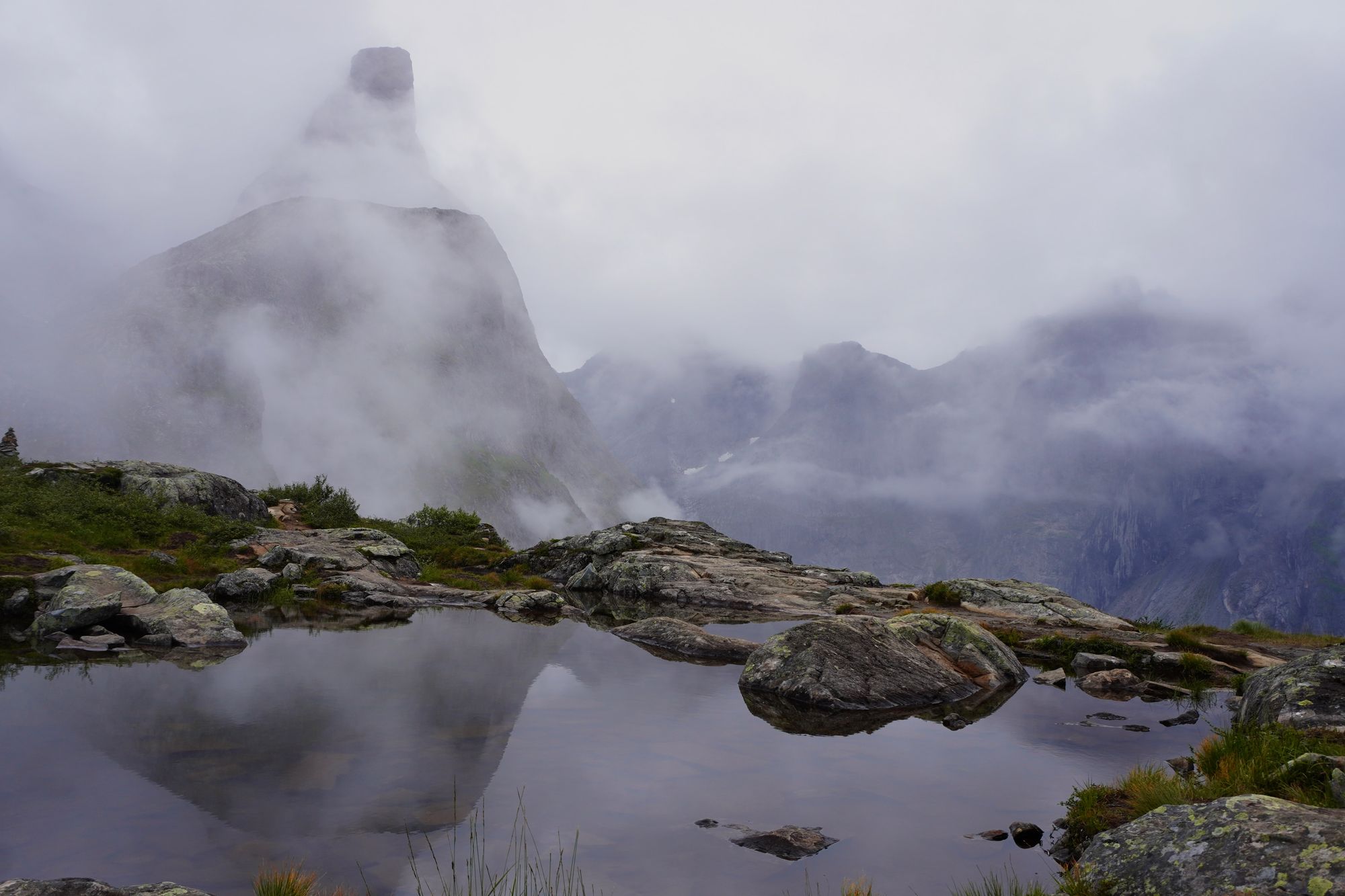 Rocky peaks reflected in a tarn in fog, Åndalsnes
