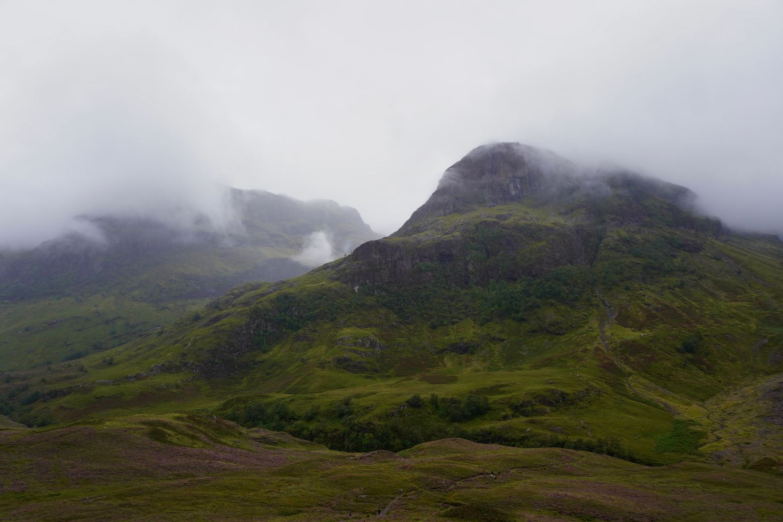 Rocky mountain above green slopes in low cloud, Loch Ness