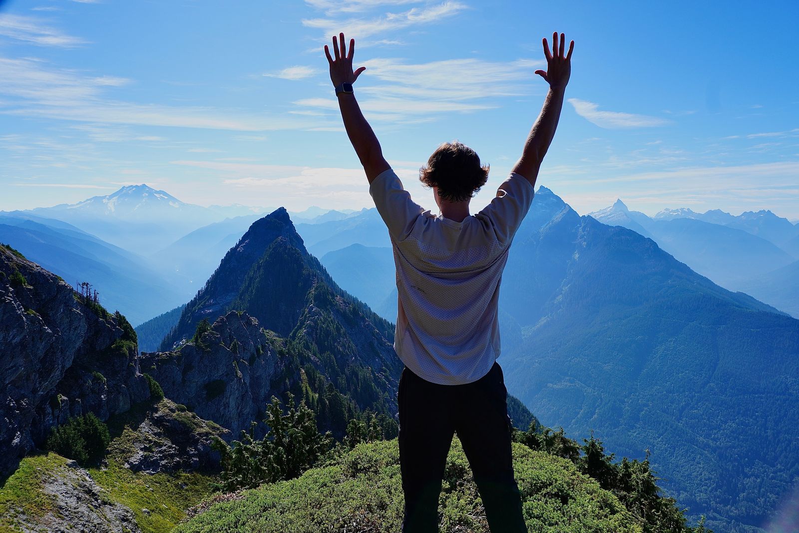 A person above forested ridges and snowy peaks, Cascades