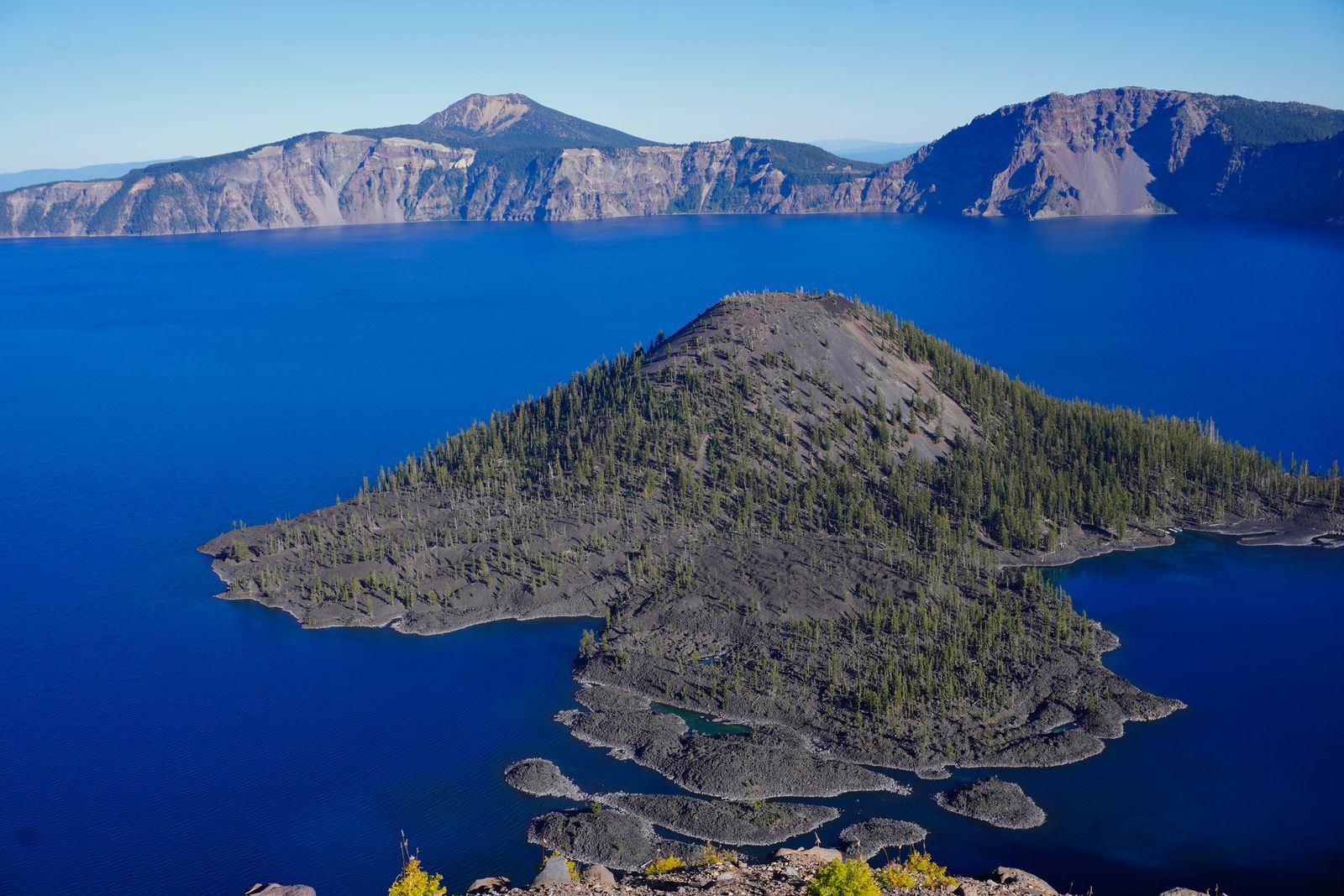 Crater Lake surrounding a rocky island below steep cliffs
