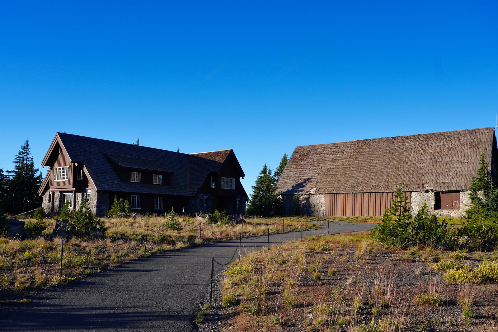 Wood and stone buildings beside a paved path, Crater Lake