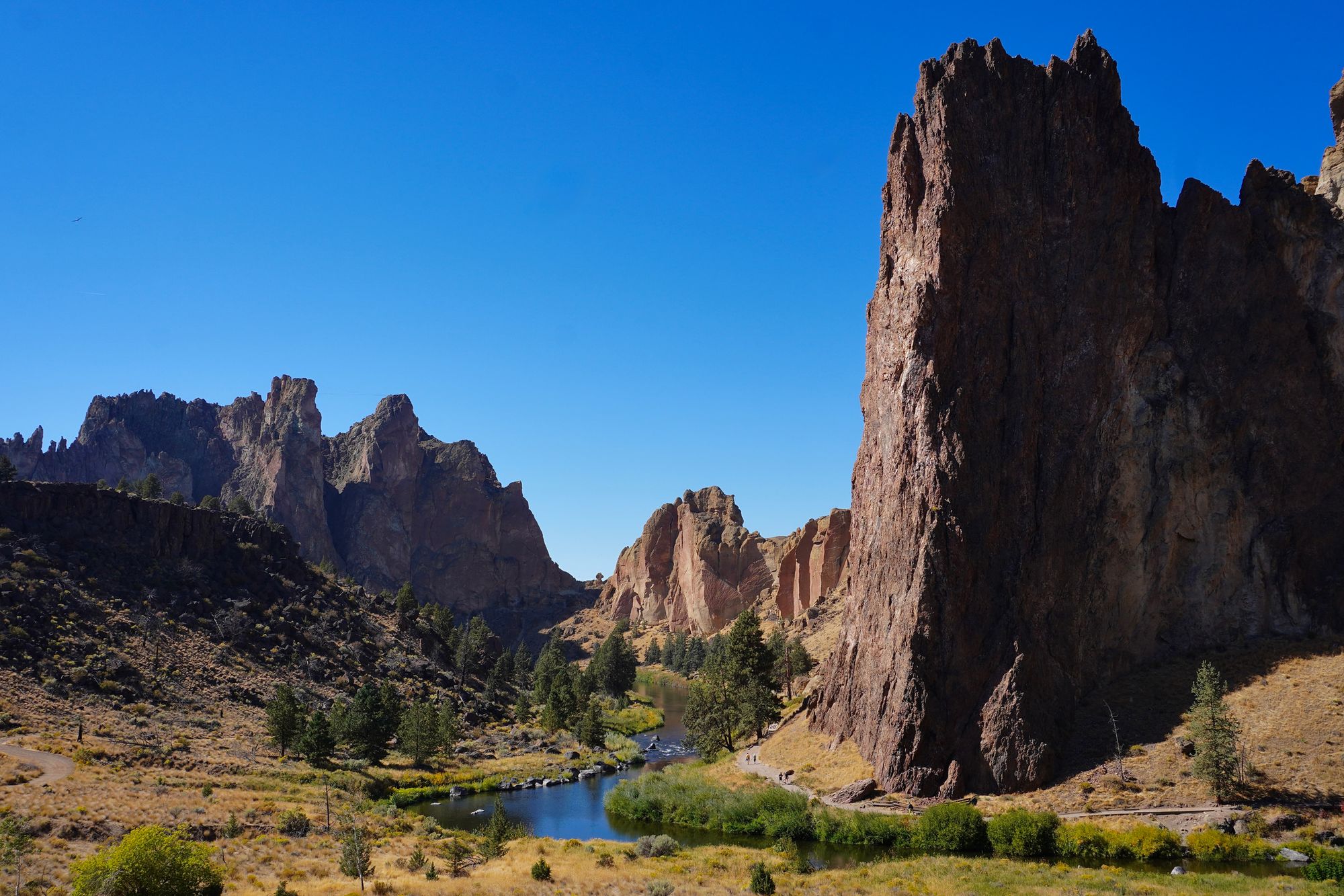 Smith Rock cliffs above a river and riverside trail