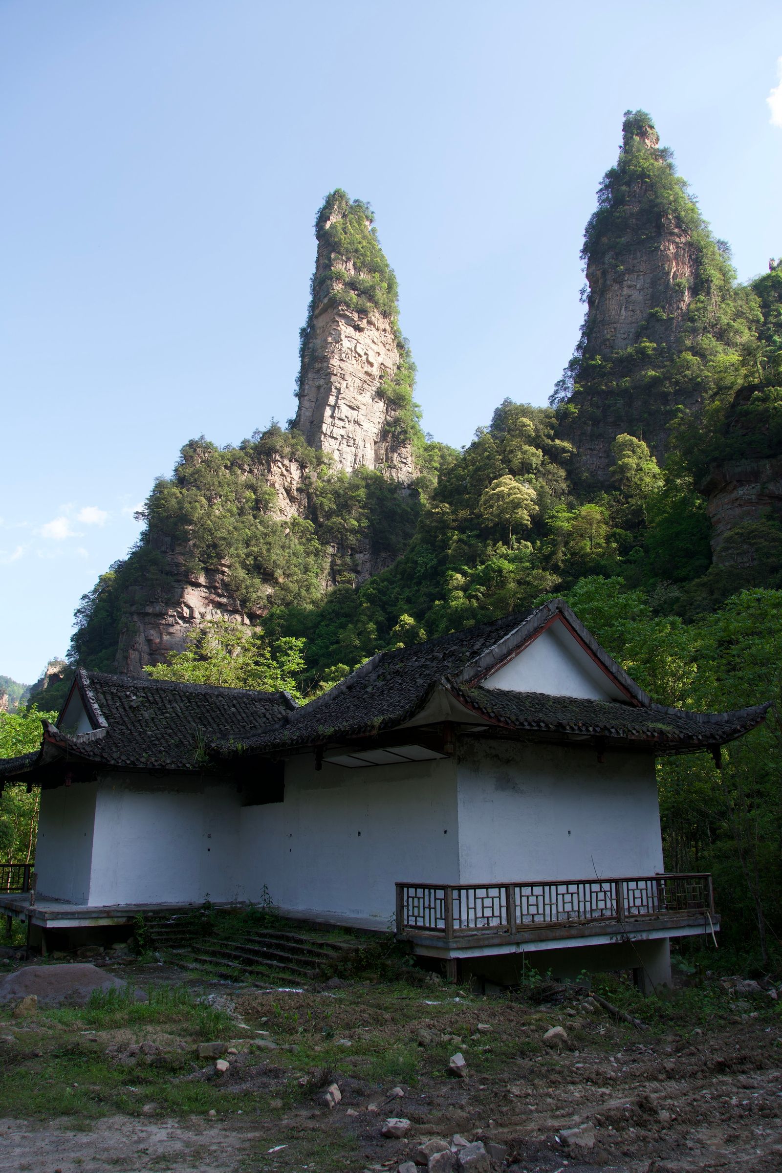 Rock pillars above a white building with dark tiled roofs, Zhangjiajie