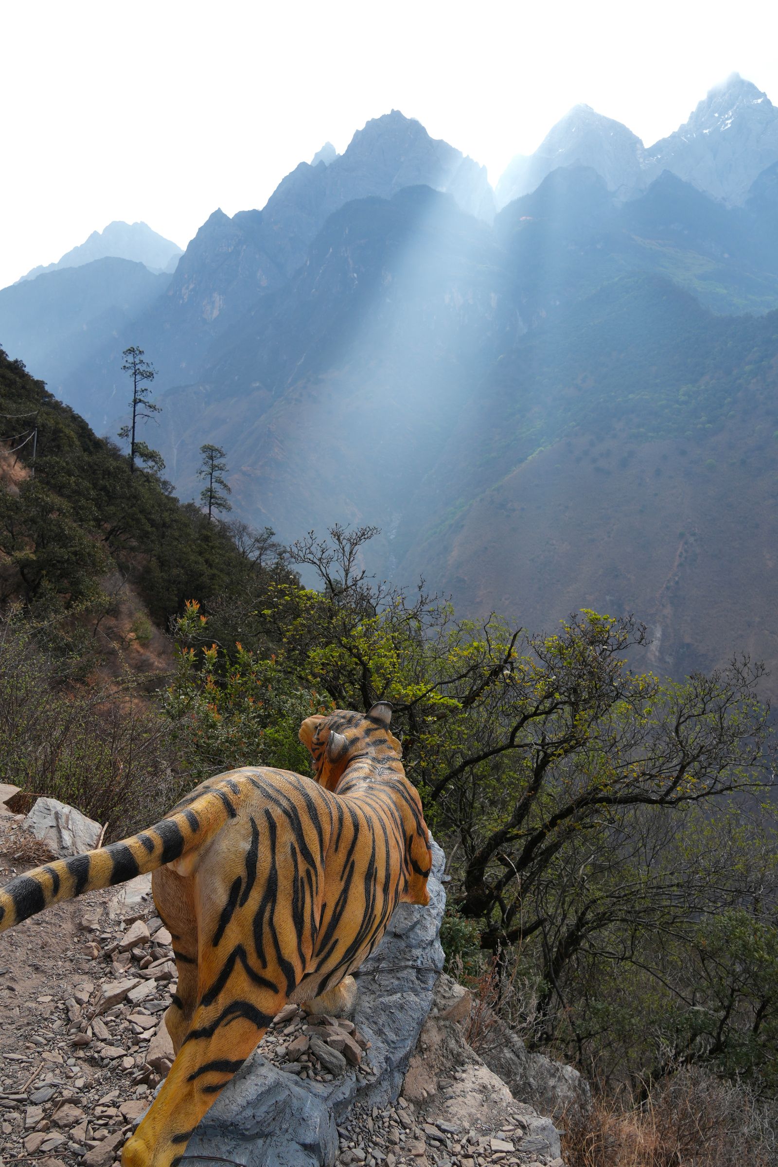 Striped animal statue above Tiger Leaping Gorge in sunlight
