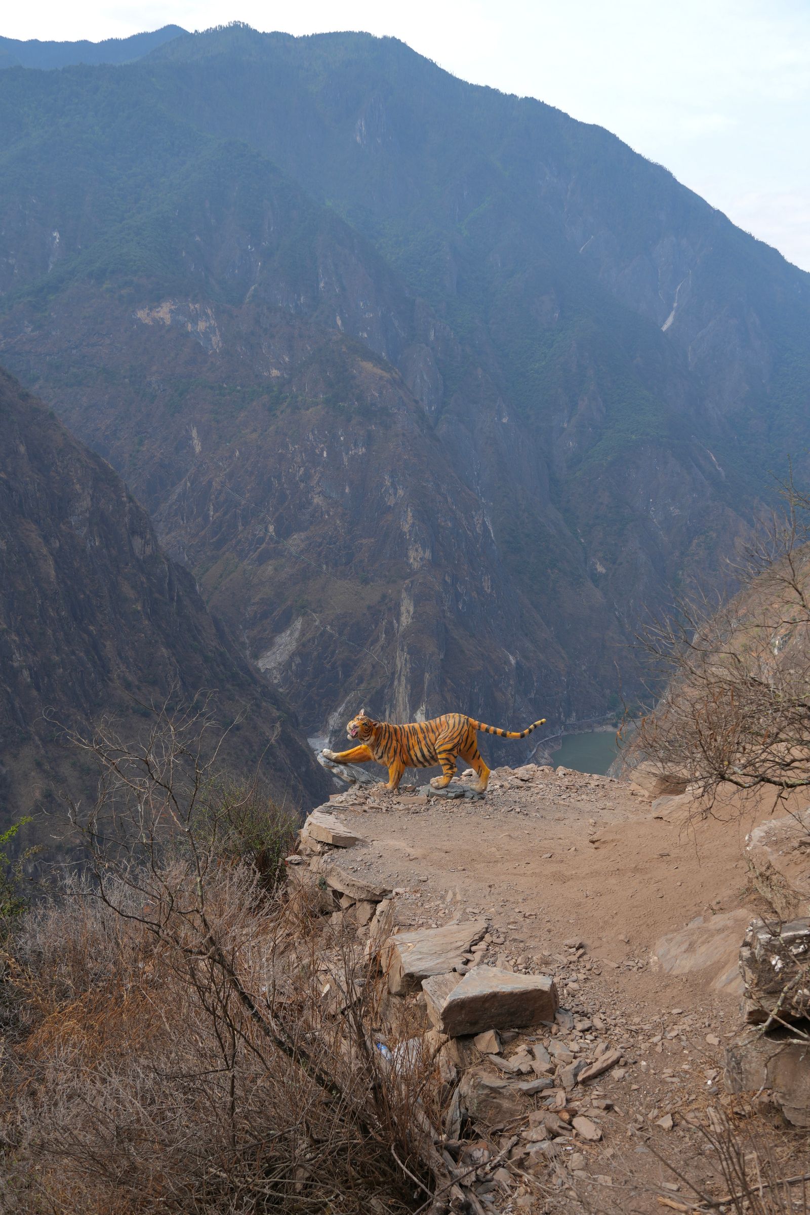 Striped animal statue on a ledge above Tiger Leaping Gorge