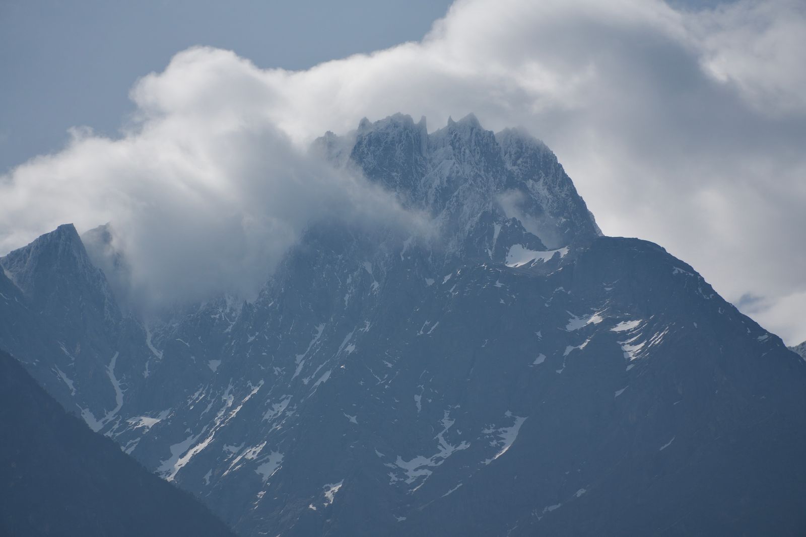 A snow-streaked mountain partly hidden by clouds, Tiger Leaping Gorge
