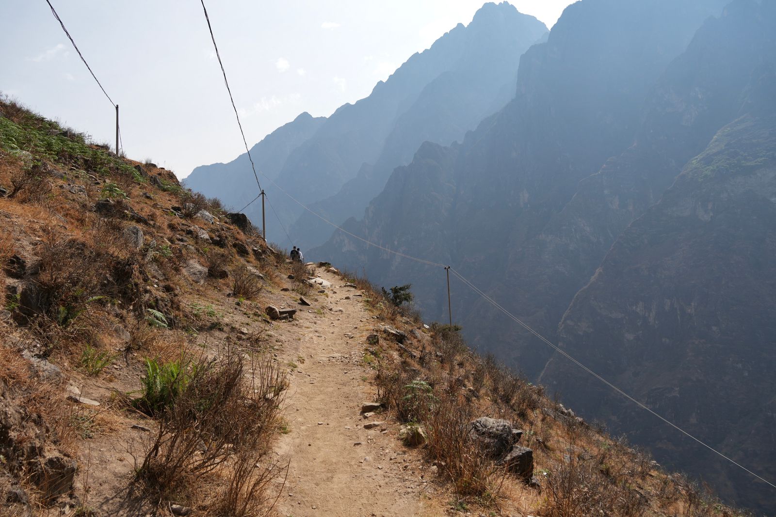 Hikers on a rocky trail above Tiger Leaping Gorge