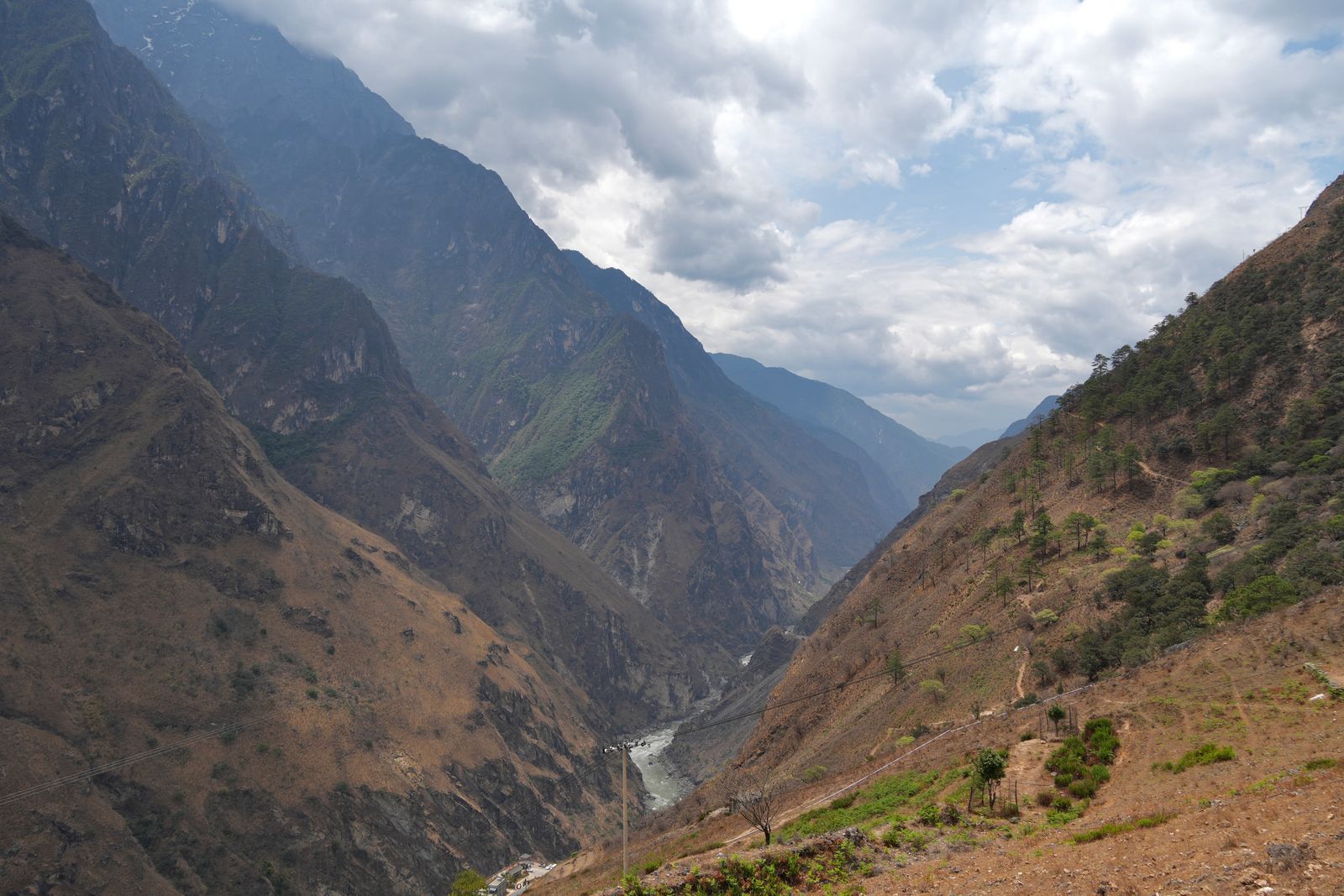 Tiger Leaping Gorge with a river below cloud-covered peaks