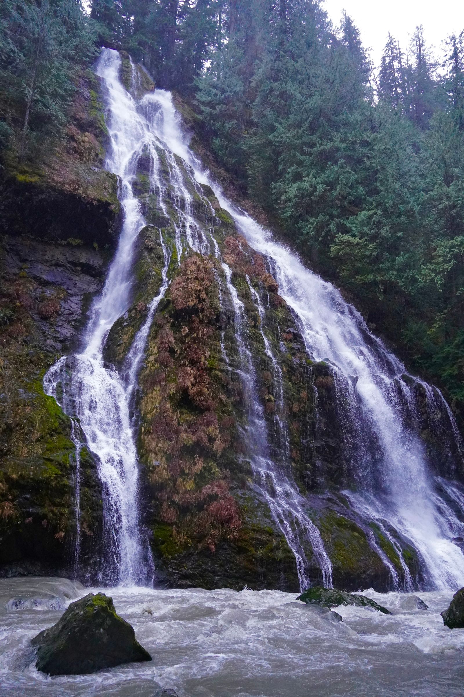 Waterfall splitting over mossy rock into a boulder-strewn stream, Cascades