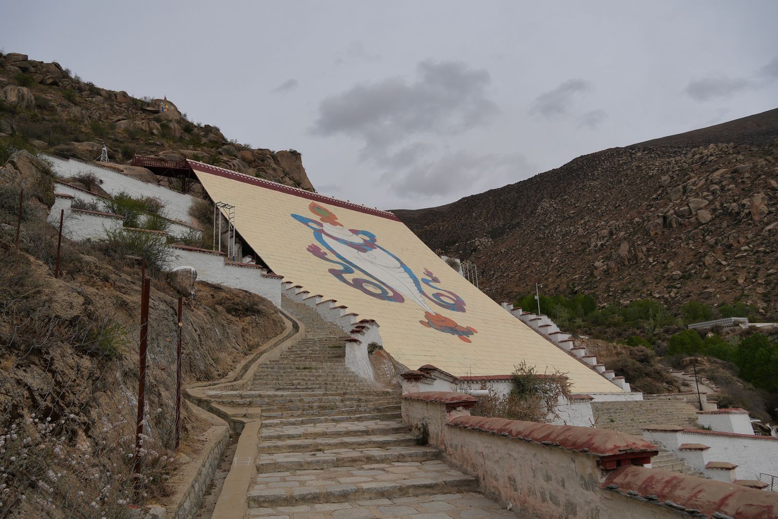 A hillside mural between stone stairways on a rocky slope, Tibetan plateau