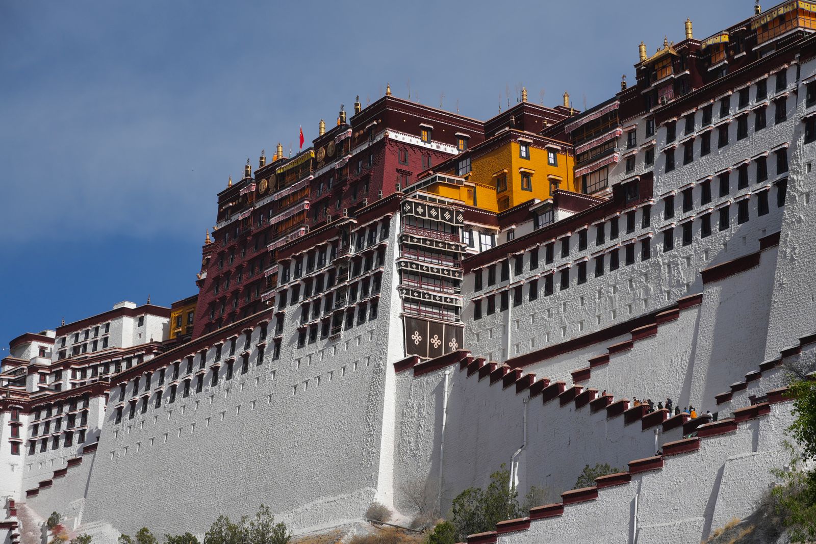 Temple complex above stepped white walls and stairways, Tibetan plateau