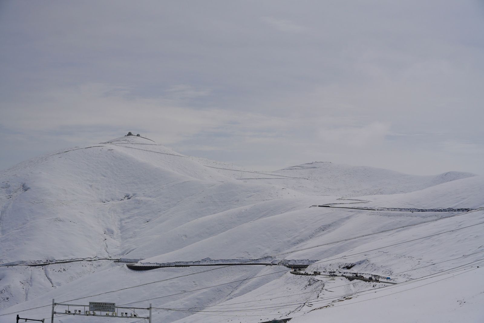 Snow-covered hills crossed by winding roads, Tibetan plateau