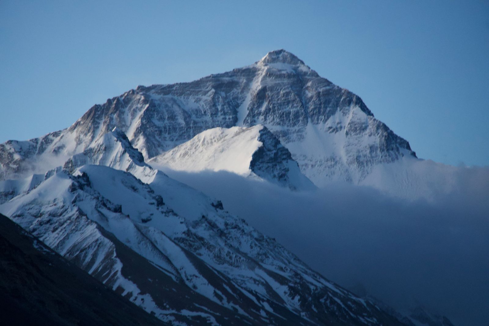 Mount Everest above snowy ridges and low clouds
