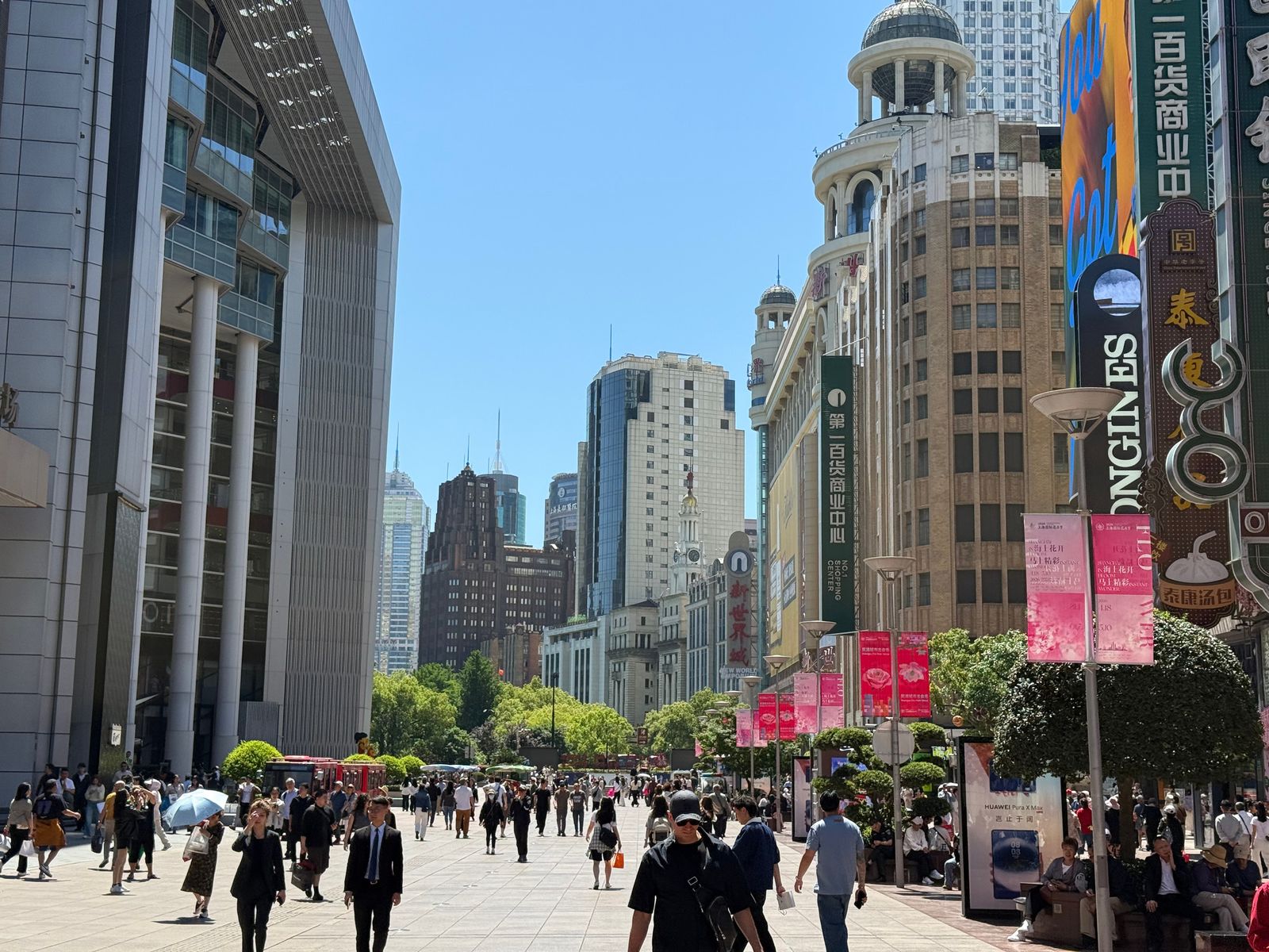 A crowded shopping street lined with tall buildings and signs, Shanghai