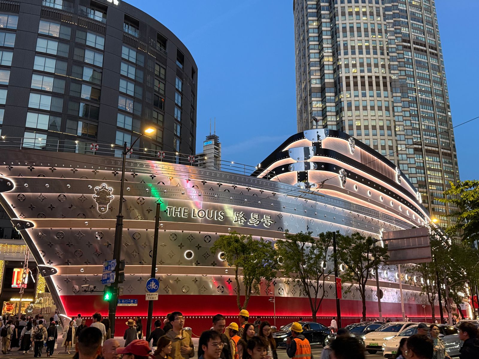 A ship-shaped building above a busy street at dusk, Shanghai