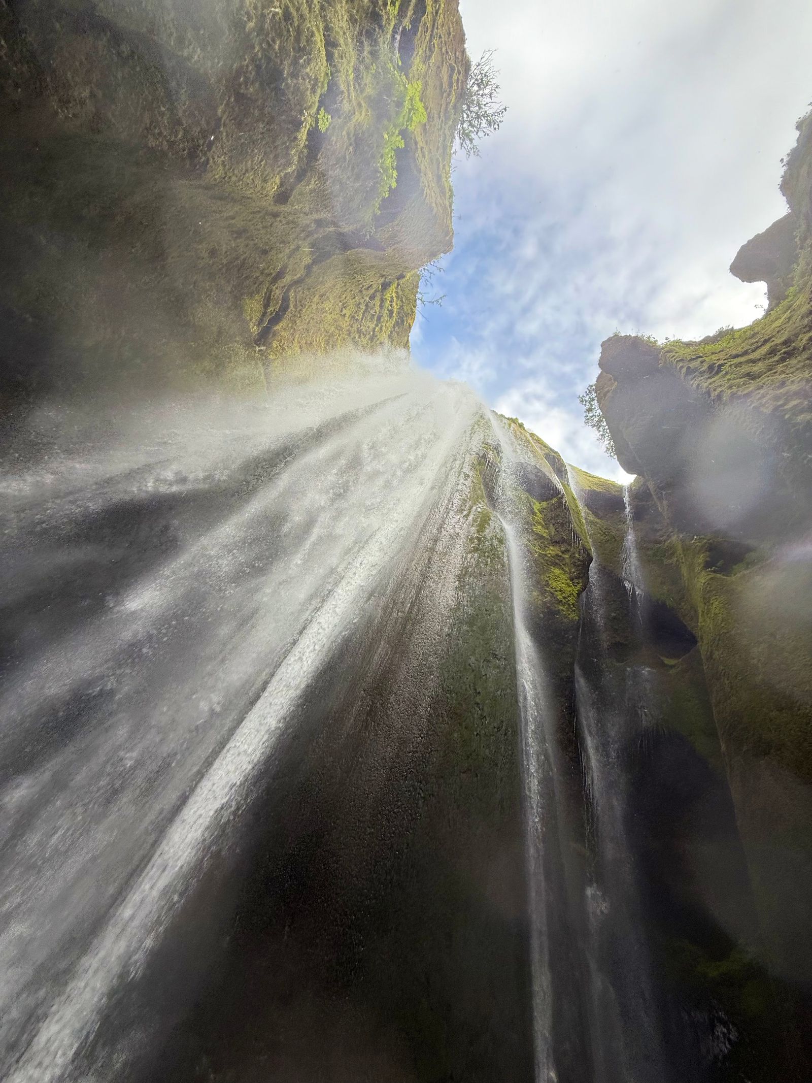 Waterfall falling between moss-covered rock walls, Skogafoss