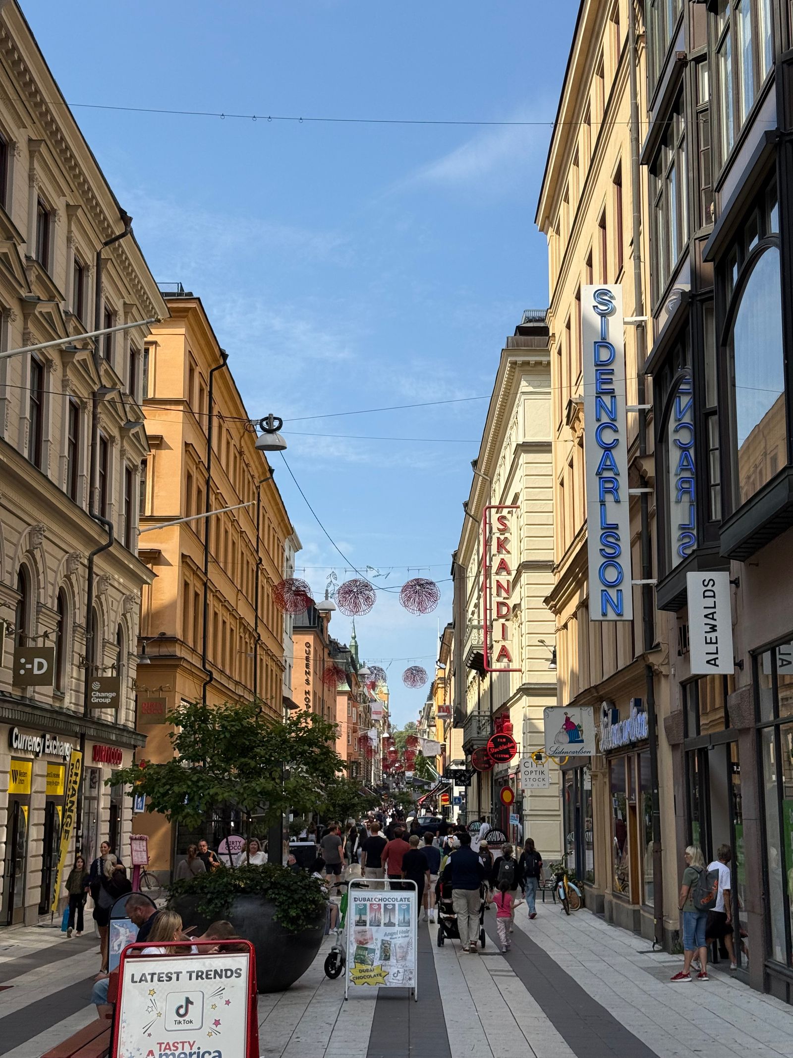 Shopping street lined with tall buildings and filled with pedestrians, Stockholm
