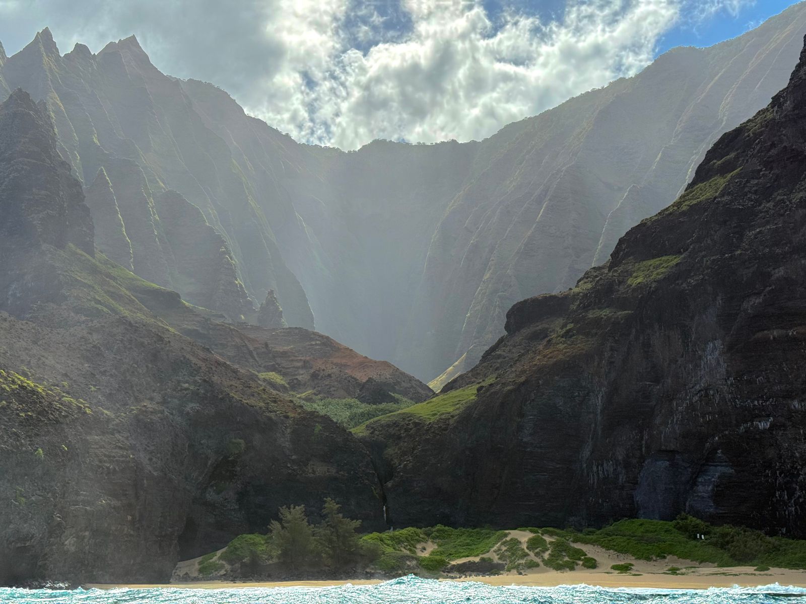 Napali Coast above a sandy beach in hazy backlight