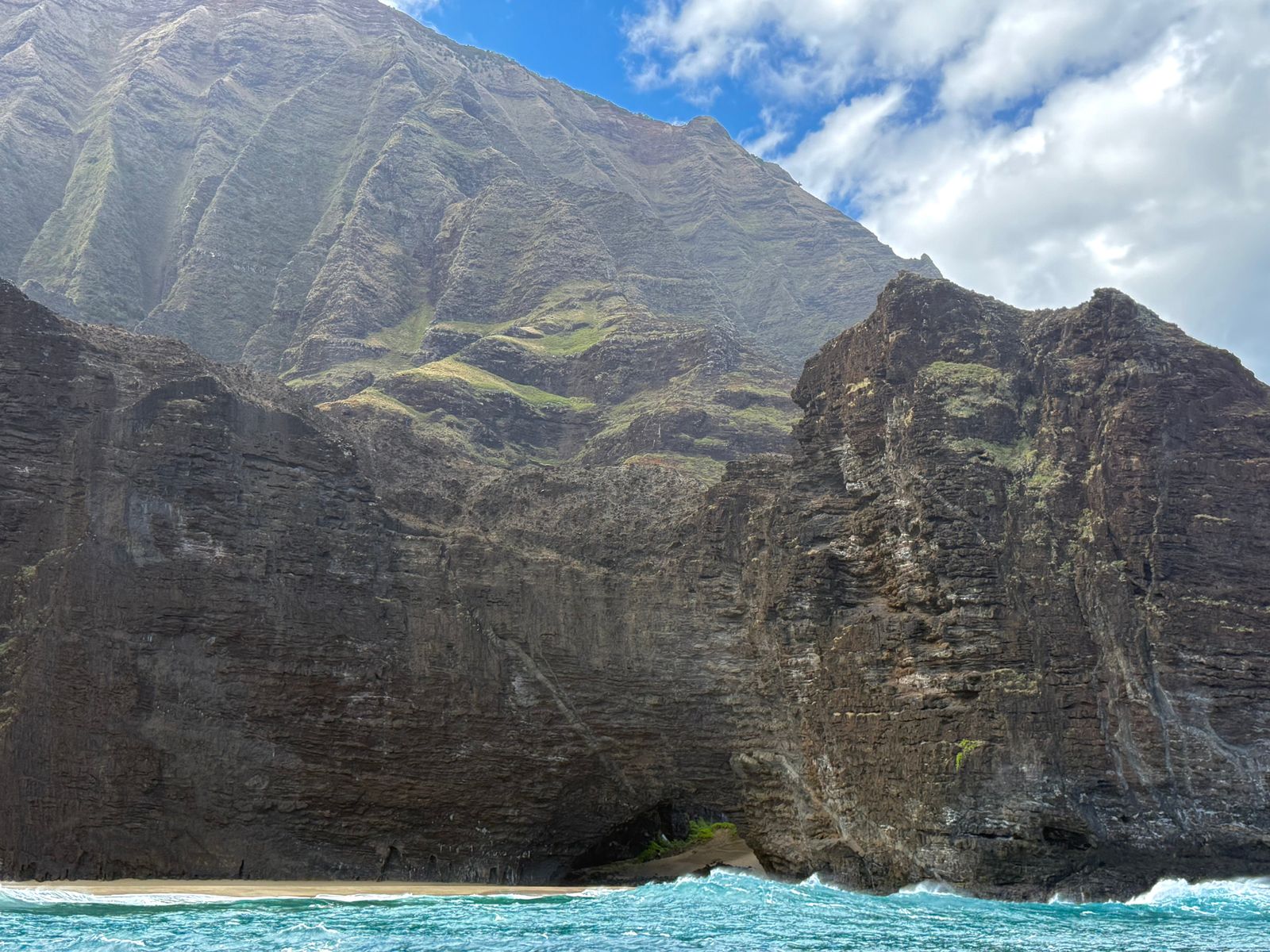 Napali Coast above a narrow beach and breaking turquoise waves